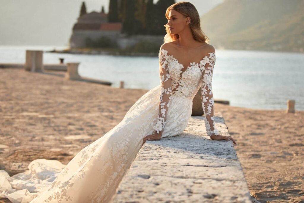 Beach bride wearing a tea-length wedding dress walking on sandy shoreline. Beach Dresses