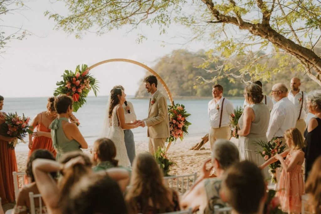 Romantic beach wedding ceremony with bride wearing an elegant coastal wedding dress at sunset